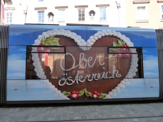 Werbeplakat Oberösterreich - Kunst, Werbung, Strassenbahn, Herz, Oberösterreich, Lebkuchen, blau, Perspektive, Fenster